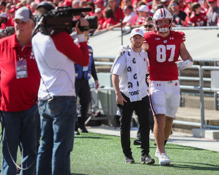 Wisconsin tight end Hayden Rucci being helped to the locker room with an injury.